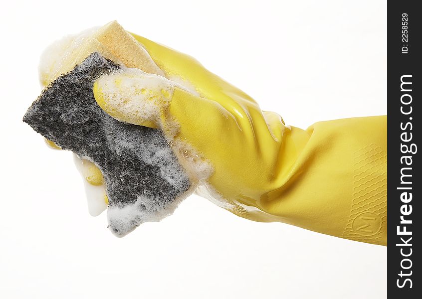 Hand in yellow rubber glove with yellow sponge and foam. Hand in yellow rubber glove with yellow sponge and foam