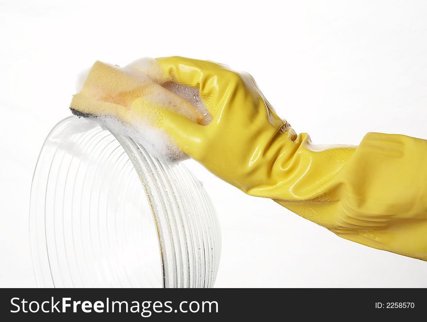 Hand in yellow rubber glove with yellow sponge and foam and plate. Hand in yellow rubber glove with yellow sponge and foam and plate