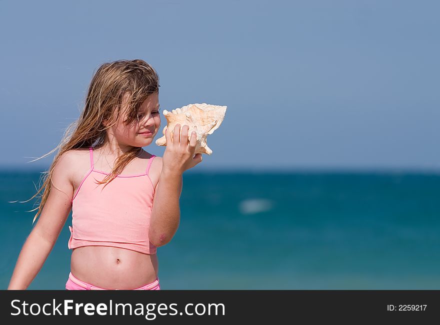 Young girl finds shell on beach. Atlantic Ocean, Florida east coast. Young girl finds shell on beach. Atlantic Ocean, Florida east coast