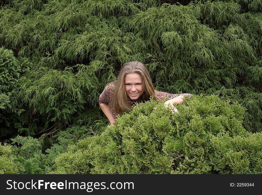 Cute girl hiding in bushes
