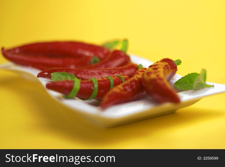Red chili with oregano on the yellow background