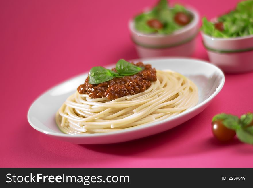 Spaghetti bolognese from Italy on the pink background