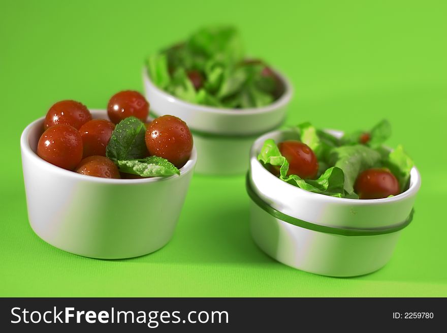 Tomato with salad on the green background