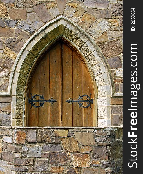 Medieval architecture with an old wooden arched doorway. Medieval architecture with an old wooden arched doorway