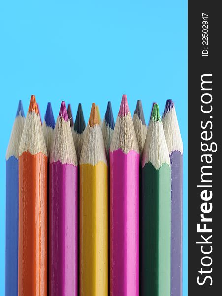 A set of colored pencils on a blue background. A set of colored pencils on a blue background