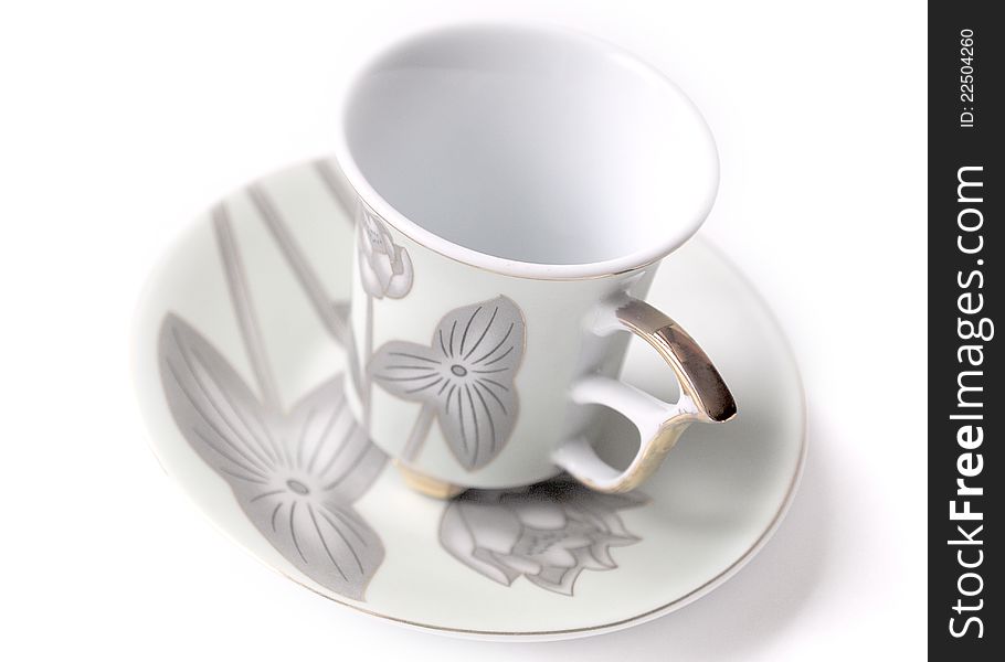 Empty cup and saucer  with pattern on white