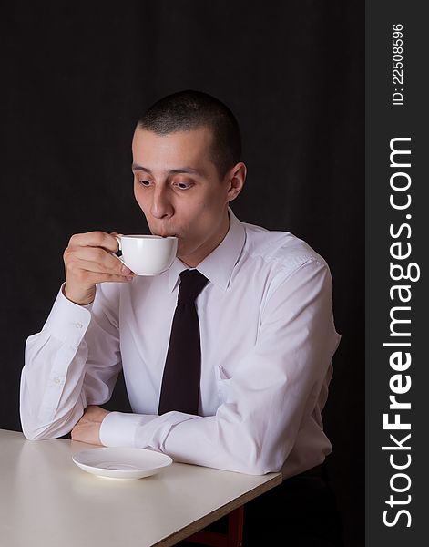 Portrait of businessman drinking coffee on black. Portrait of businessman drinking coffee on black