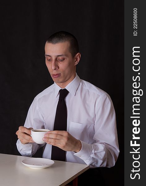 Portrait of businessman drinking coffee on black. Portrait of businessman drinking coffee on black