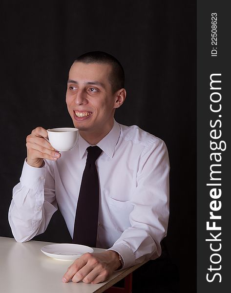 Portrait of businessman drinking coffee on black. Portrait of businessman drinking coffee on black