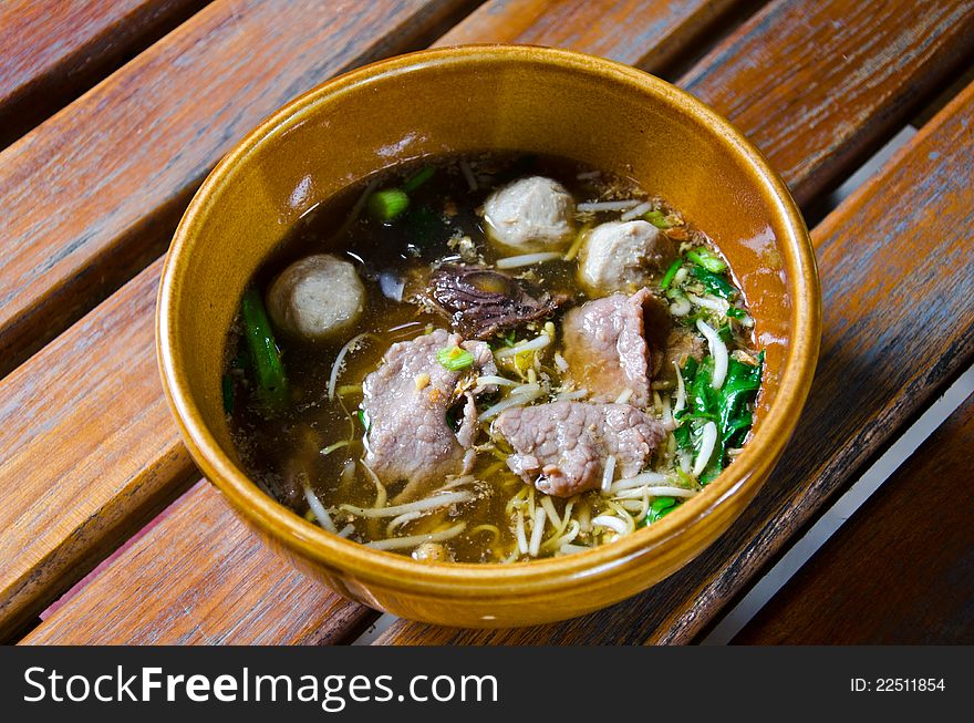 Asian soup with noodles and meat ball.