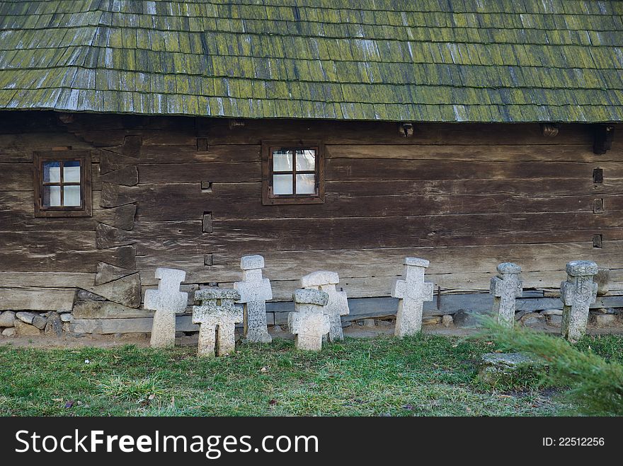 Museum of the Romanian Peasant, interior court and view over a wooden house with some crosses in the grass. Museum of the Romanian Peasant, interior court and view over a wooden house with some crosses in the grass