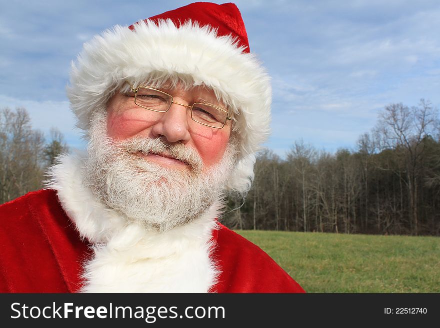 Santa smiling as he poses in an open field. Santa smiling as he poses in an open field.