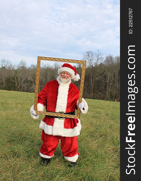 Santa in an open field holding a frame. Santa in an open field holding a frame.