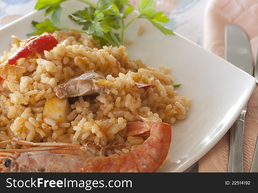 Dish of paella rice with prawns and chunks of meat