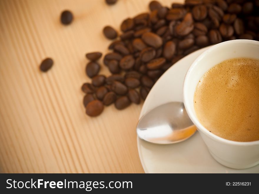 Cup of hot coffee, with coffee beans in the background. Cup of hot coffee, with coffee beans in the background