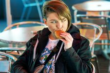 Portrait Of Girl With Eats Burger On The Terrace Stock Photos