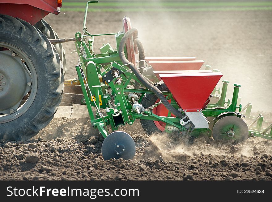 Tractor and seeder planting crops on a field