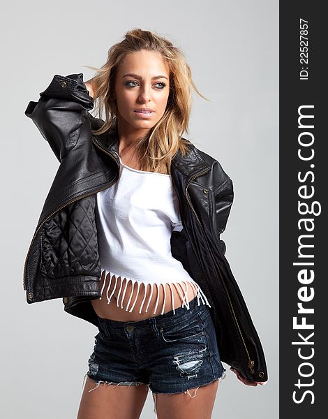 Blonde model in jean shorts, white top, and leather jacket. Blonde model in jean shorts, white top, and leather jacket