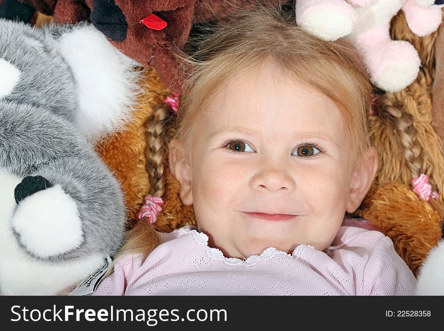 Portrait of a young girl with pigtails on the background of toys. Portrait of a young girl with pigtails on the background of toys