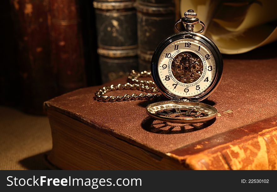 Still life with stylish pocket watch on ancient book. Still life with stylish pocket watch on ancient book