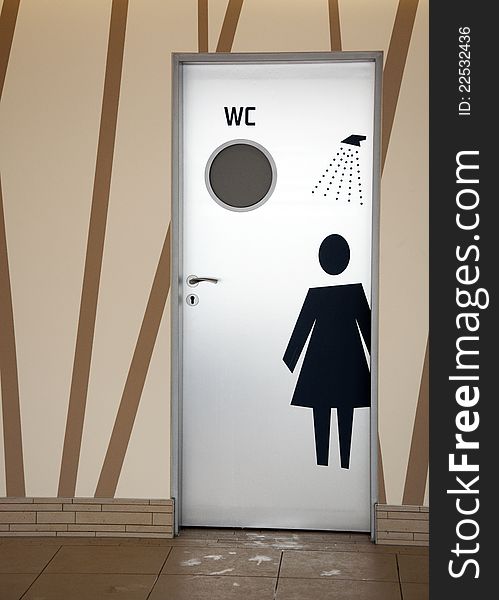Door with sings of female shower and WC room in a contemporary design. Door with sings of female shower and WC room in a contemporary design.