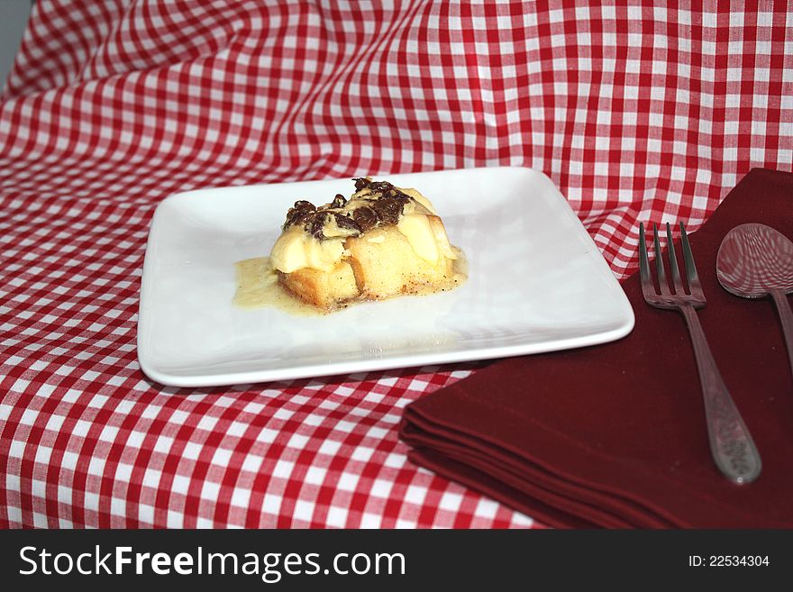 This photo shows a Bread and Butter Pudding complete with napkin and cutlery