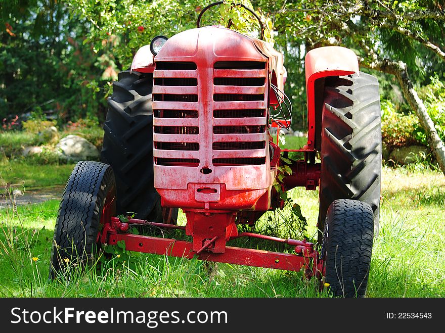 Derelict farm tractor sitting in an orchard. Derelict farm tractor sitting in an orchard