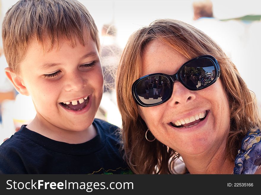 An older mother or grandmother with an 8 year old boy. Boy and women are laughing hysterically with a huge smile. Image taken outdoors. An older mother or grandmother with an 8 year old boy. Boy and women are laughing hysterically with a huge smile. Image taken outdoors.