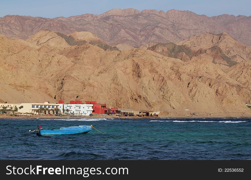 Boat, palms and mountains on windy sea shore in Egypt, Dahab. Boat, palms and mountains on windy sea shore in Egypt, Dahab