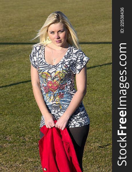 Young lady on a football field with a red jacket