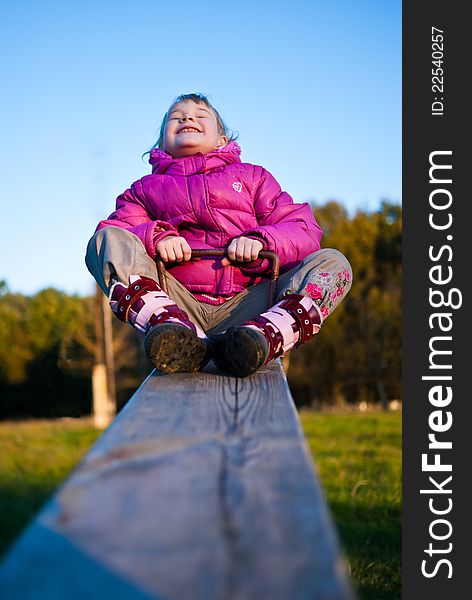 Girl riding on a swing and joyful laughs.
