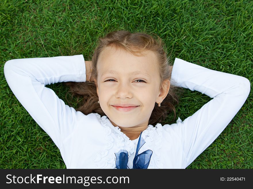 Ð¡ute little girl lying on a green lawn. Ð¡ute little girl lying on a green lawn