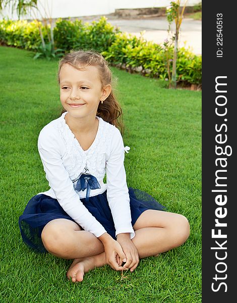 Ð¡ute little girl sitting on a green lawn. Ð¡ute little girl sitting on a green lawn