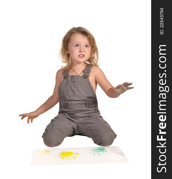 Pretty little girl with disheveled hair and palms in paint making prints on paper sheets isolated on white background. Pretty little girl with disheveled hair and palms in paint making prints on paper sheets isolated on white background