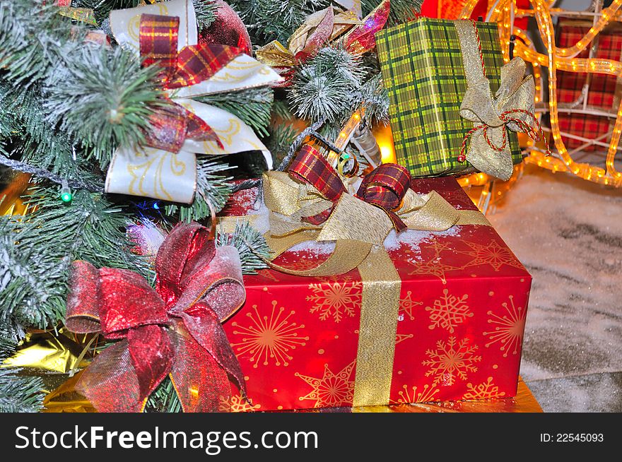 Colorful boxes with Christmas gifts under a decorated fir tree. Colorful boxes with Christmas gifts under a decorated fir tree