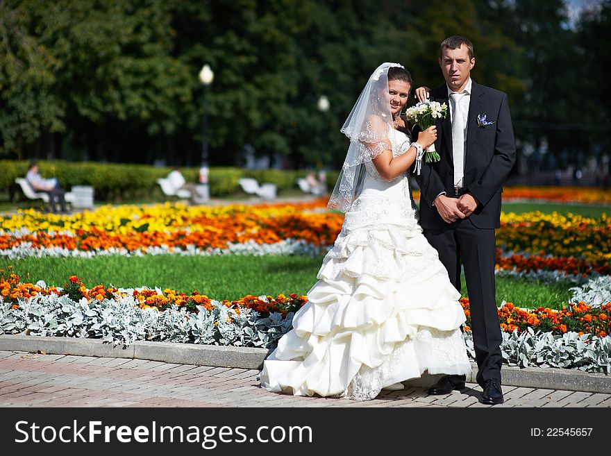 Happy groom and bride wedding walk in the park