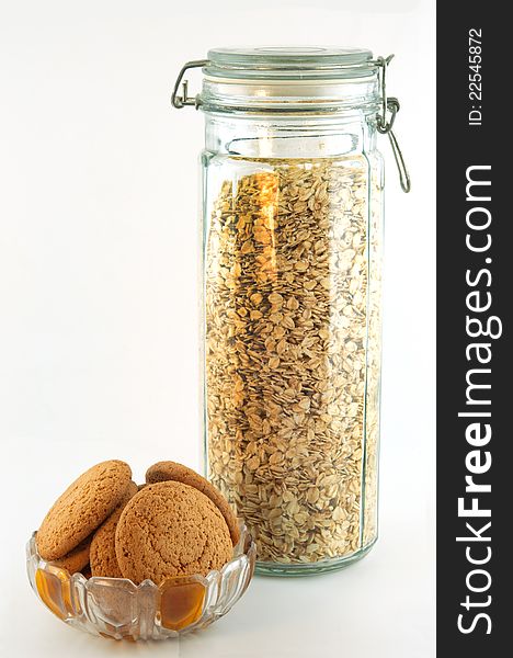 Oat flakes in a high glass jar and oat biscuits in a bowl. Oat flakes in a high glass jar and oat biscuits in a bowl