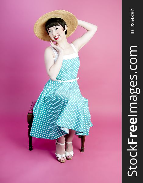 Cute pinup model wearing straw hat and polka dot dress. Cute pinup model wearing straw hat and polka dot dress