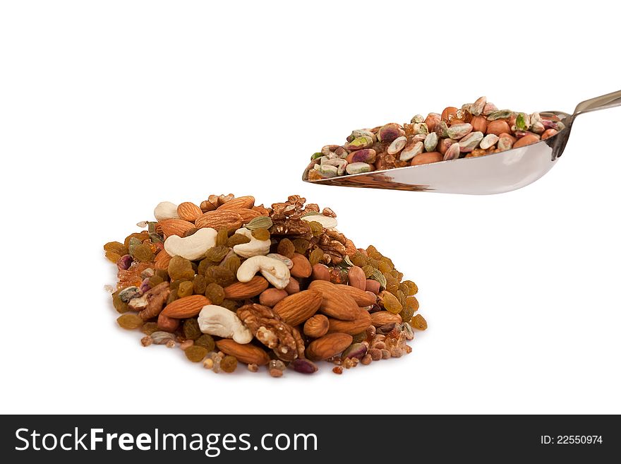 Pile of mix collection of dry fruits falling from steel spoon isolated over white. Pile of mix collection of dry fruits falling from steel spoon isolated over white