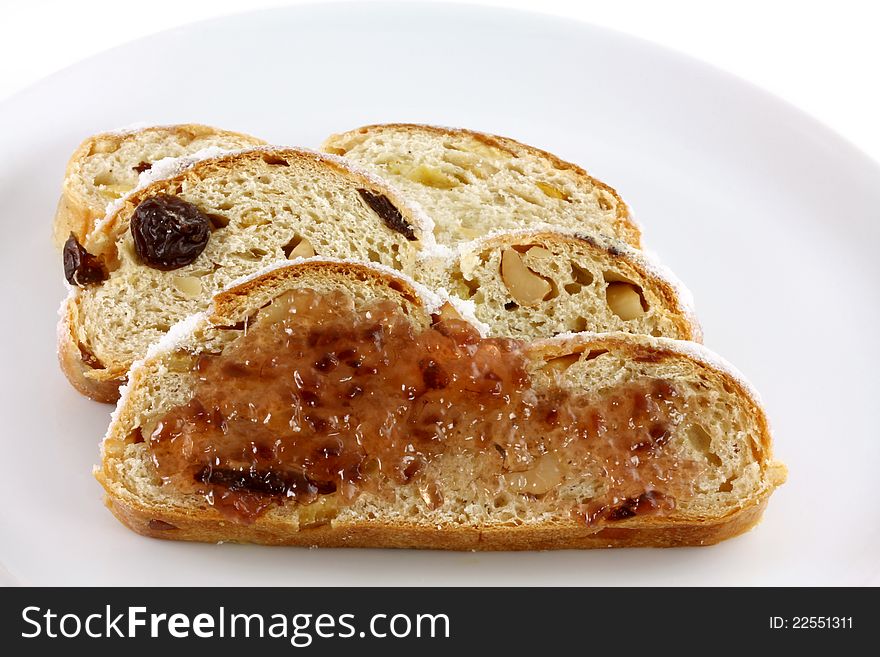 Sweet Jam on a slice of homemade Christmas stollen cake with raisins, nuts, spices and chopped dried fruit