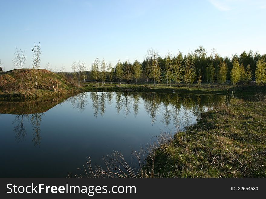 Idyllic rural Pond with sky and trees mirrored in it. Idyllic rural Pond with sky and trees mirrored in it.