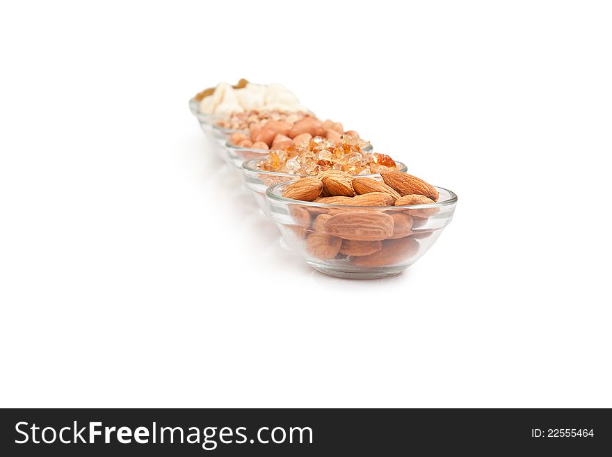 Mix collection of dry fruits in glass bowl over white. Mix collection of dry fruits in glass bowl over white