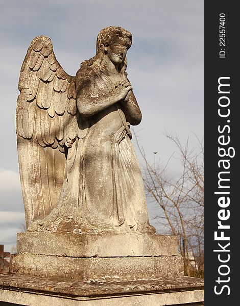 Figure of a praying angel on a blue sky