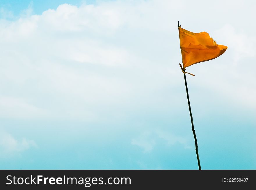 A frayed yellow flag warning about the danger of an approaching hurricane. A frayed yellow flag warning about the danger of an approaching hurricane.