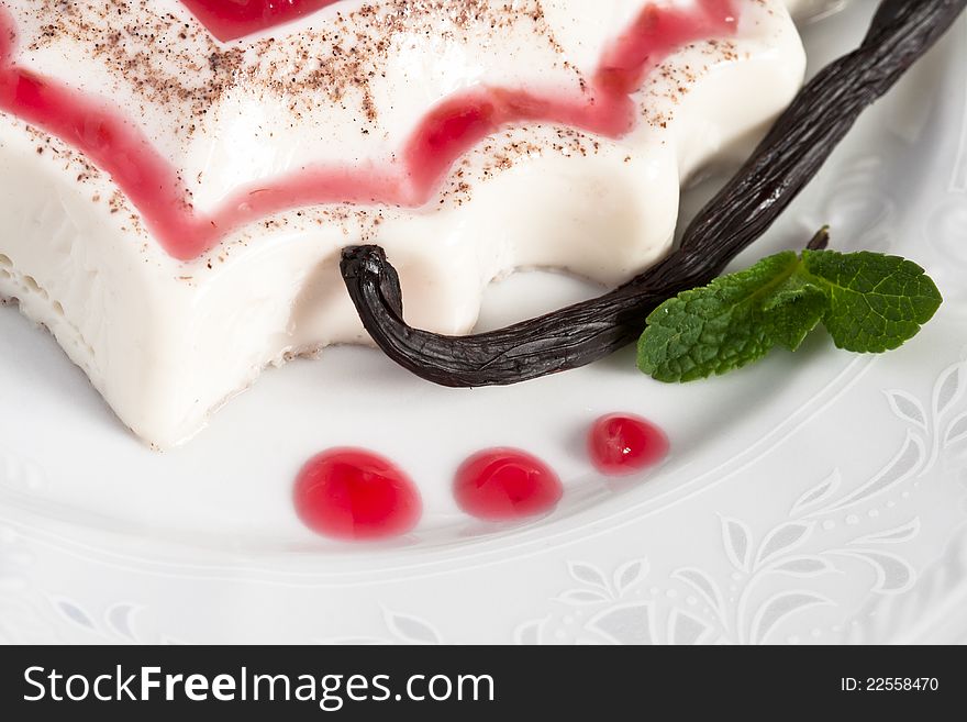 Panna cotta dessert with sweet sauce (raspberry), vanilla and mint.