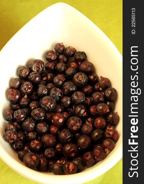 Close-up of dry juniper berries in a white bowl