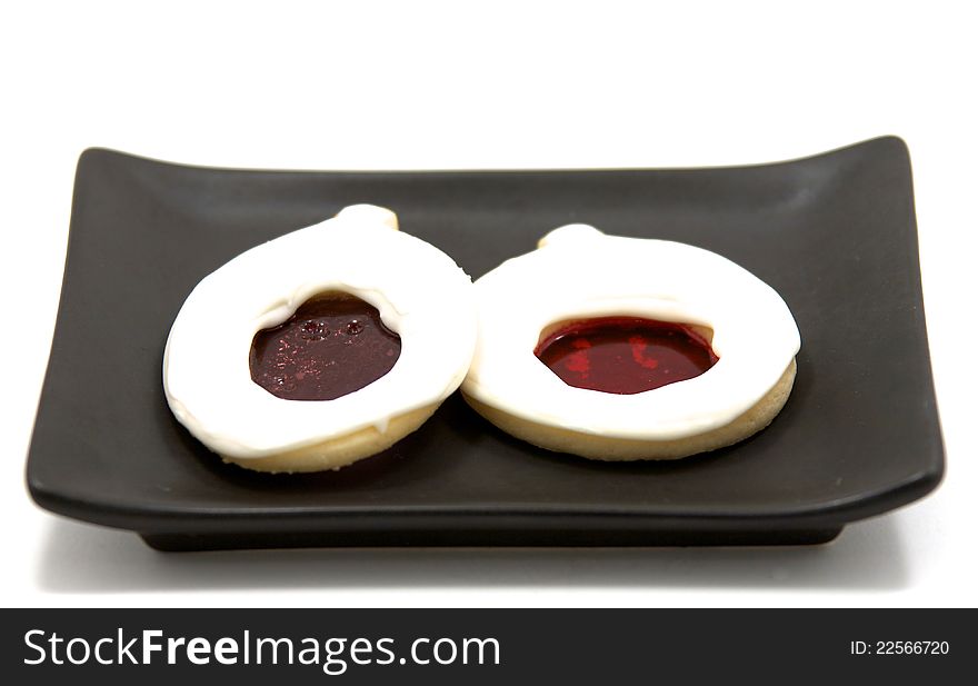 White cookies with melted sugar middles on a black plate. White cookies with melted sugar middles on a black plate