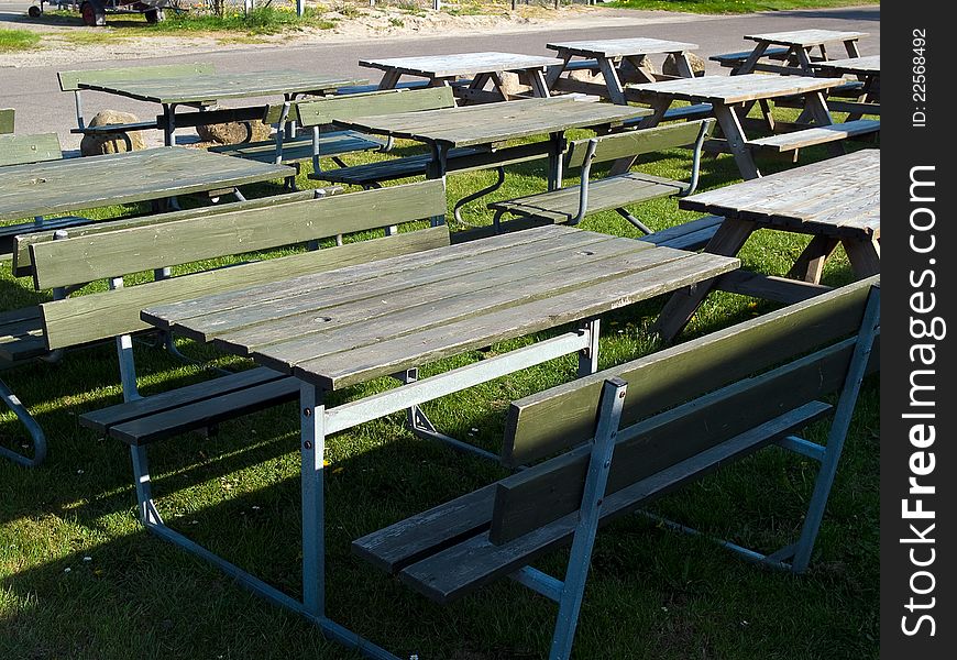 Wooden picnic tables arranged outdoors in nature