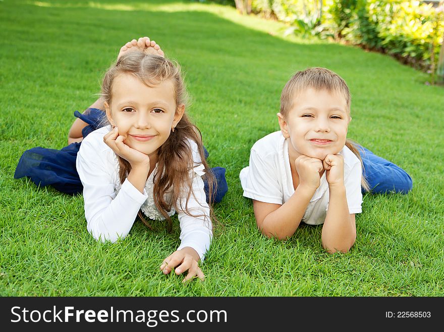 Boy and girl lying on green grass