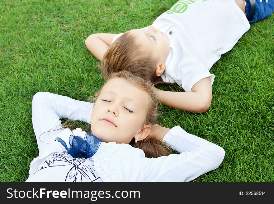 Boy and girl lying on green grass